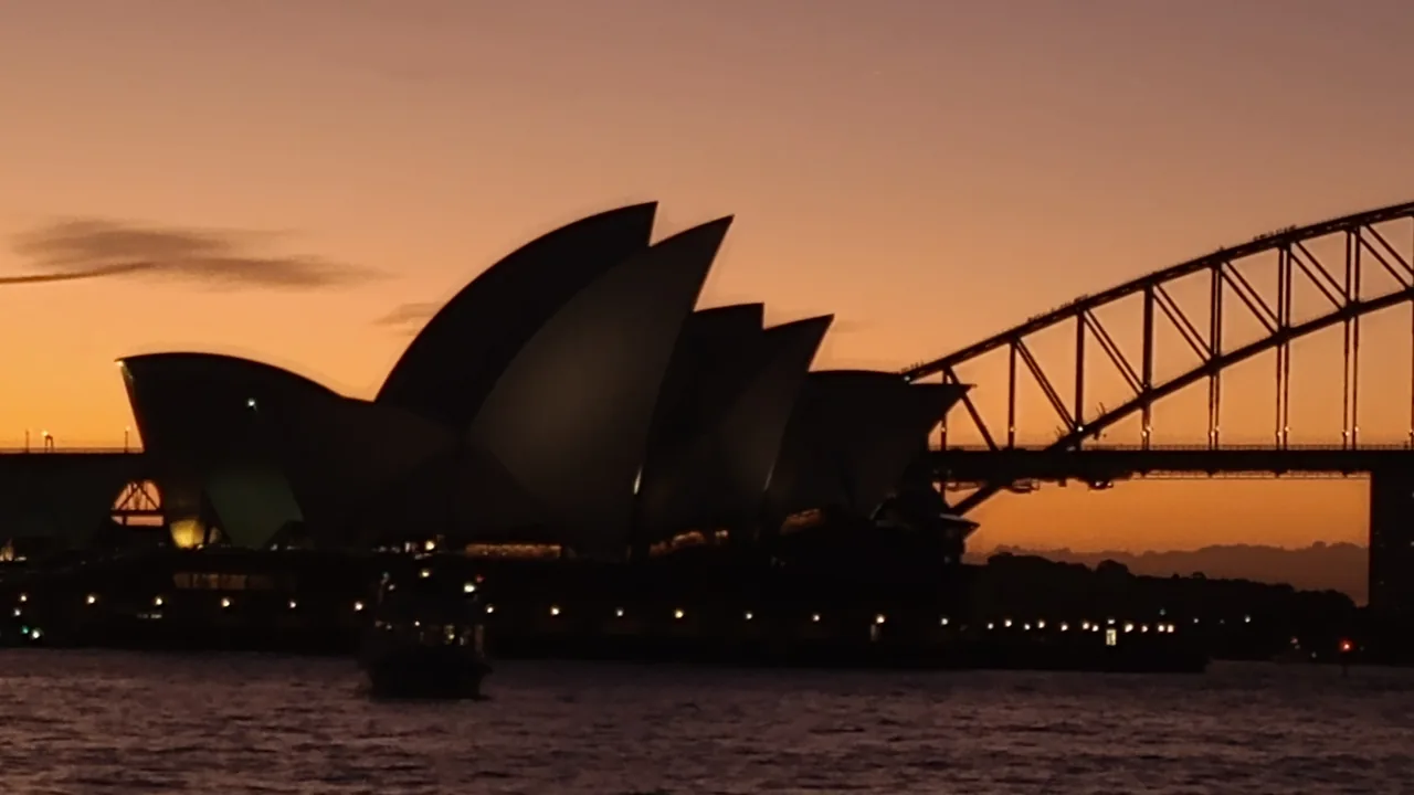 Sydney Opera Binası ve Avustralya kıyı kentinin gün batımı görünümü
